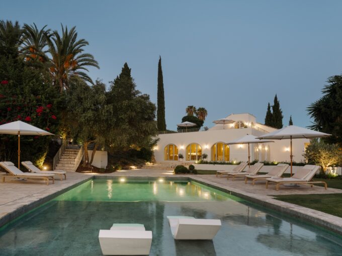 Evening view of the swimming pool at a luxury villa for sale in Nueva Andalucía, Marbella, showcasing the outdoor space in the evening light.